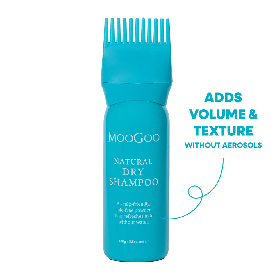 A turquoise blue bottle of MooGoo Natural Dry Shampoo with a matching wide-tooth comb applicator on top, shown on a white background. Increase Volume and texture while refreshing hair with no aerosols. 