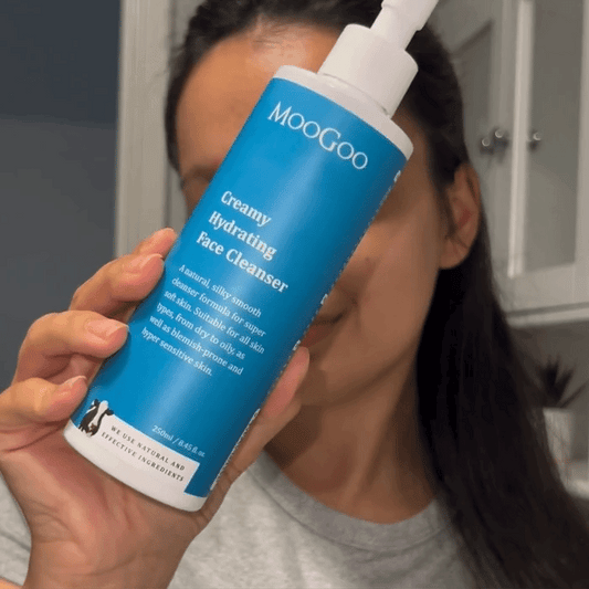Woman applying MooGoo Creamy Hydrating Face Cleanser 250ml on white backdrop, natural face cleanser for all skin types, Silky Smooth Formula With Hyaluronic Acid for Soft, Hydrated Skin