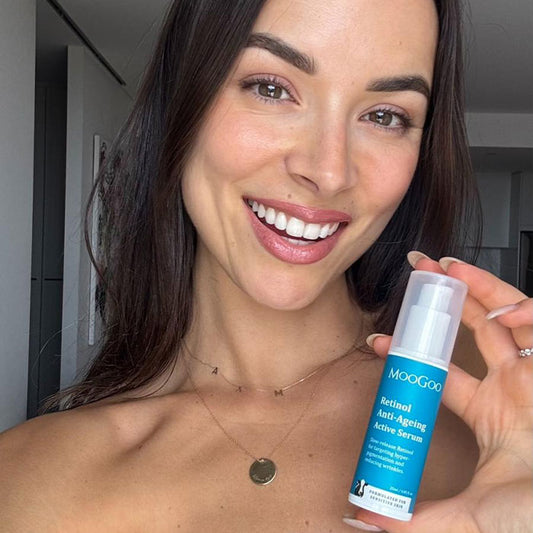 Happy woman with glowing skin holding MooGoo Retinol Anti-Ageing Active Serum, Vitamin A skincare for ageing concerns