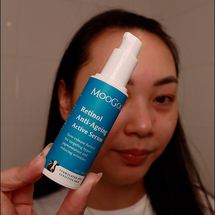 Young woman holding MooGoo Retinol Anti-Ageing Active Serum with the lid off - Vitamin A skincare for ageing, pigmentation, acne and texture concerns.