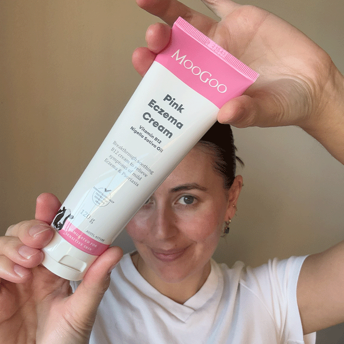 Person holding a tube of MooGoo Pink Eczema Cream