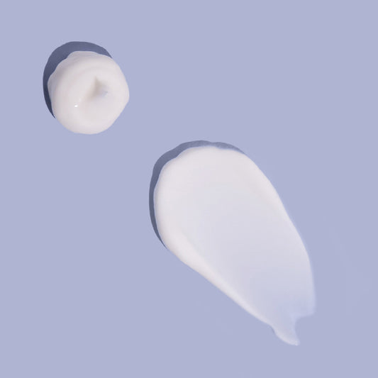 Dollops of MooGoo baby and child natural fast absorbing lotion with ceramides on a surface.